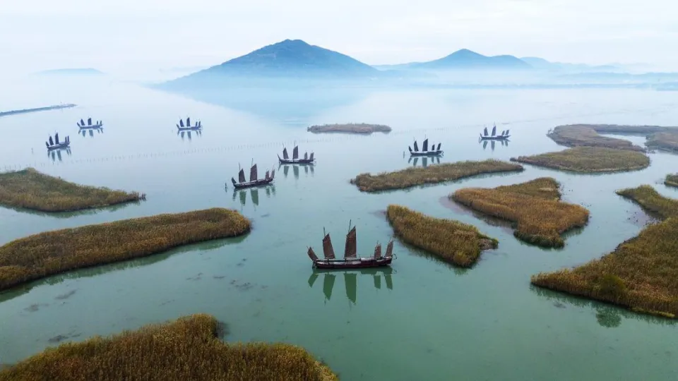 On November 23, 2025, in Suzhou, Jiangsu, the sails on Taihu Lake near Chongshan Village, Guangfu Town, Wuzhong District, floated on the horizon, presenting a quiet and beautiful scene as far as the eye could see.